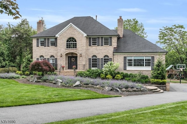 146 Linden Dr, Bernards Twp, NJ 07920 - view of front facade with a chimney, brick siding, and a front yard