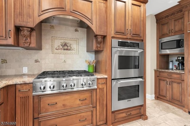 146 Linden Dr, Bernards Twp, NJ 07920 - kitchen featuring stainless steel appliances, decorative backsplash, light tile patterned flooring, and brown cabinets
