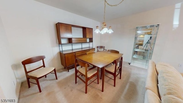 dining space featuring light colored carpet and an inviting chandelier