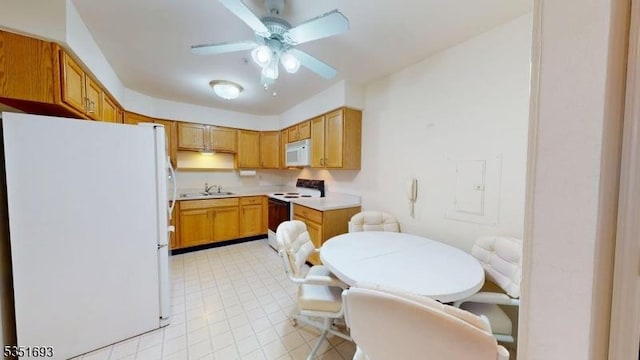 kitchen featuring light countertops, a sink, ceiling fan, and white appliances