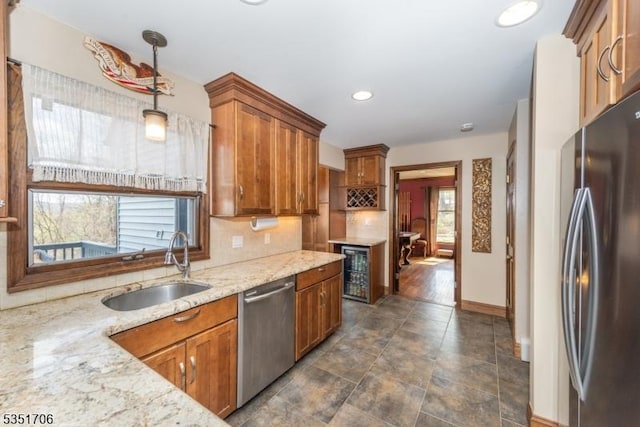 kitchen featuring brown cabinets, stainless steel appliances, baseboards, and a sink