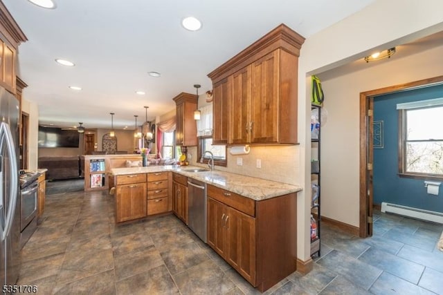 kitchen featuring brown cabinets, a sink, stainless steel appliances, light stone countertops, and a peninsula