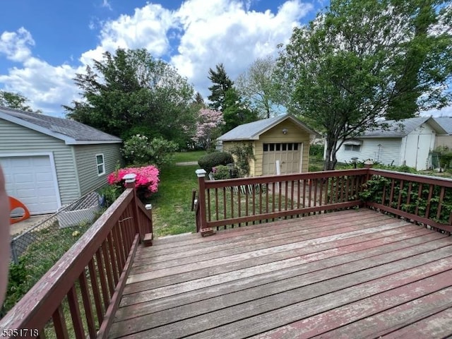 deck featuring an outdoor structure, a lawn, and a detached garage