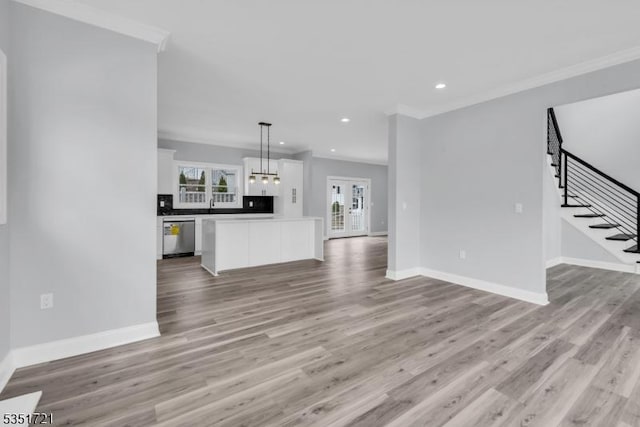 unfurnished living room featuring stairway, crown molding, light wood finished floors, baseboards, and recessed lighting
