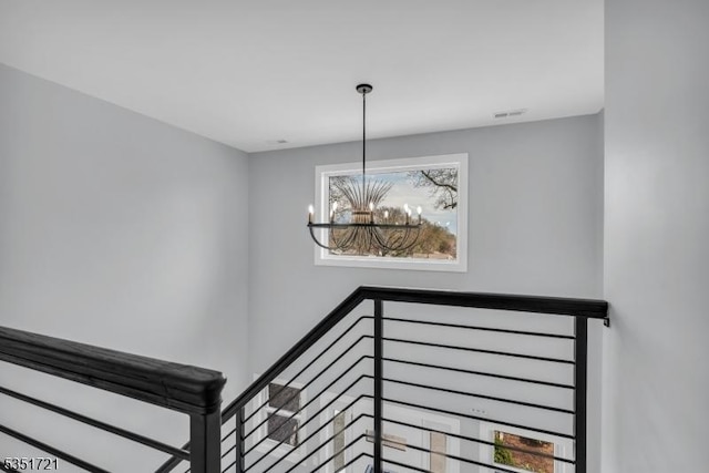 stairs with visible vents and a chandelier