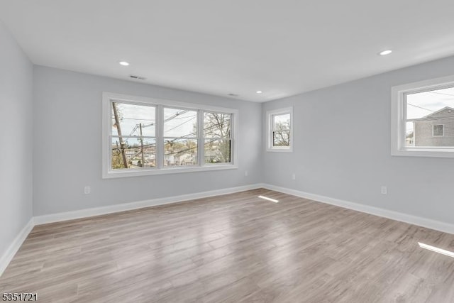 empty room featuring recessed lighting, light wood-type flooring, visible vents, and baseboards
