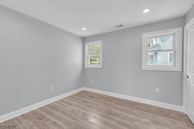 empty room featuring baseboards, visible vents, recessed lighting, and light wood-style floors