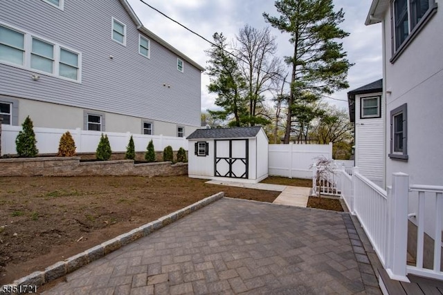 view of patio / terrace with a fenced backyard, an outdoor structure, and a storage unit