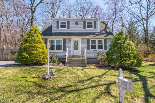 bungalow-style house with fence, a shingled roof, and a front lawn