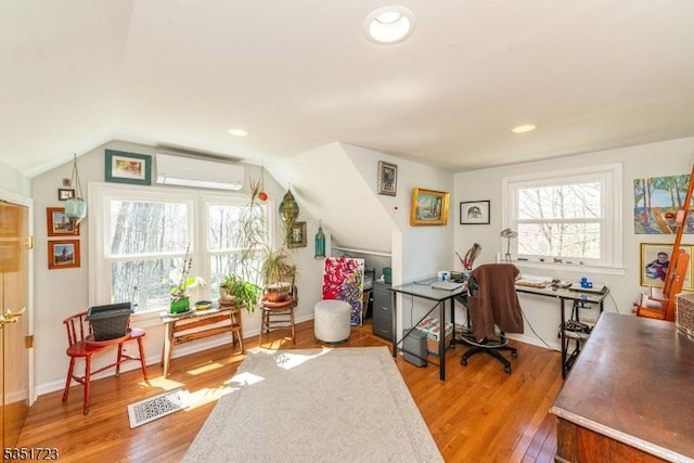 office space featuring vaulted ceiling, wood finished floors, a wall unit AC, visible vents, and recessed lighting
