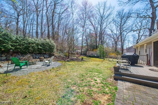 view of yard with fence, a fire pit, and a deck