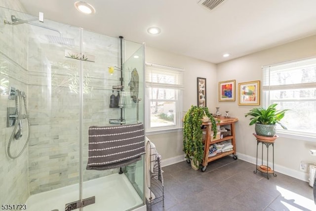 bathroom with a shower stall, visible vents, baseboards, and a healthy amount of sunlight