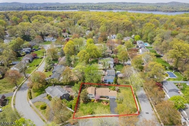 bird's eye view featuring a residential view, a water view, and a wooded view