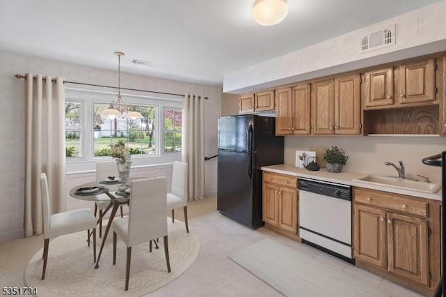 kitchen with a sink, dishwasher, light countertops, freestanding refrigerator, and pendant lighting