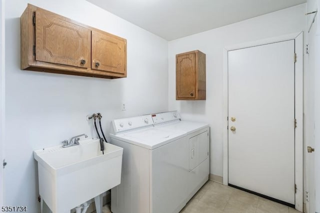 washroom with cabinet space, a sink, and washer and clothes dryer