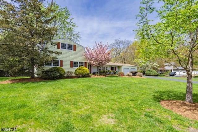 view of front of home featuring driveway, a front yard, and a garage