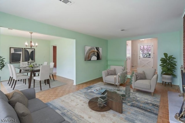 living room with visible vents and an inviting chandelier