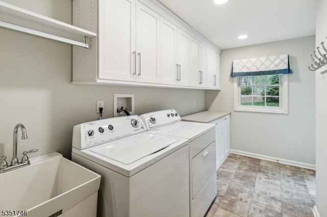 washroom featuring cabinet space, a sink, recessed lighting, baseboards, and washing machine and dryer