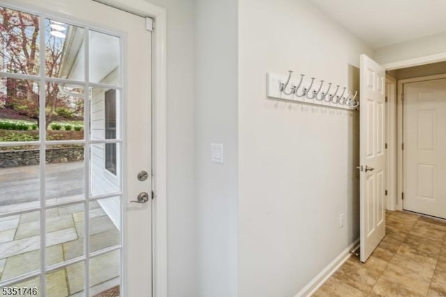 doorway with baseboards and a healthy amount of sunlight