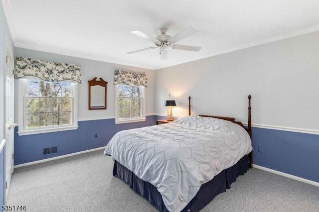 carpeted bedroom featuring baseboards, ornamental molding, ceiling fan, and visible vents