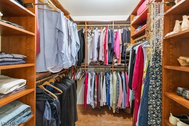 walk in closet with wood finished floors