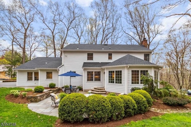 back of property featuring a patio area and a chimney