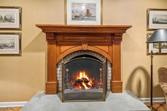 interior details featuring baseboards and a lit fireplace