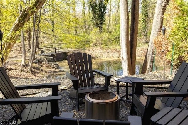 view of patio / terrace with a fire pit and a water view