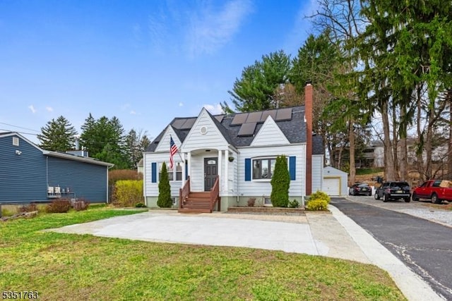 bungalow featuring a front lawn, a chimney, and solar panels
