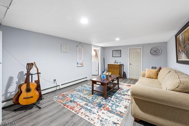 living room featuring recessed lighting, a baseboard heating unit, wood finished floors, and visible vents