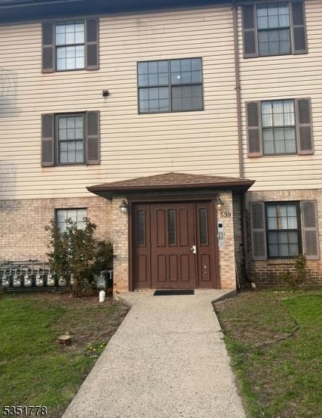 539 Bayway Ave Unit 2B, Elizabeth City, NJ 07202 - doorway to property featuring a lawn and brick siding