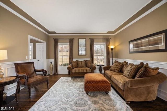 living area with dark wood-style floors, wainscoting, and ornamental molding