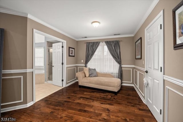 living area featuring visible vents, hardwood / wood-style floors, ornamental molding, and wainscoting