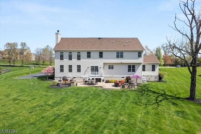rear view of property featuring a patio, a chimney, and a lawn