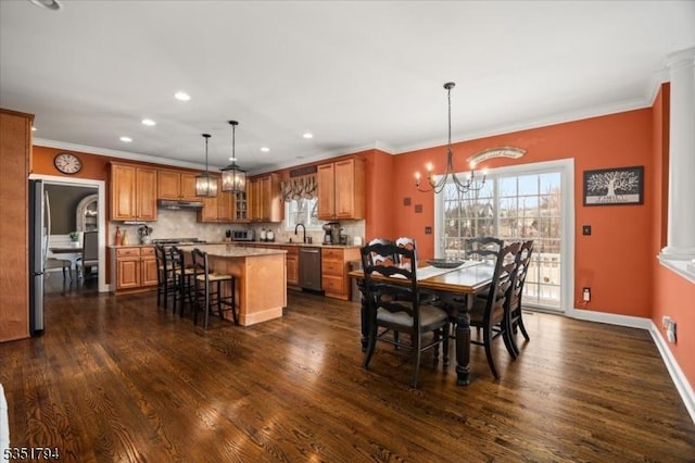 dining space featuring crown molding, recessed lighting, a notable chandelier, and dark wood finished floors