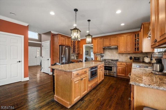 kitchen with stainless steel appliances, light stone countertops, ornamental molding, and under cabinet range hood