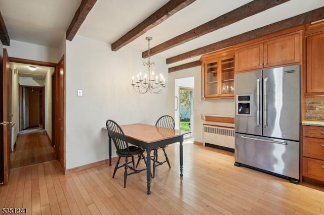 dining area with light wood-style floors, radiator, baseboards, a notable chandelier, and beam ceiling