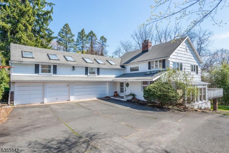 view of front facade with a chimney, driveway, and a garage