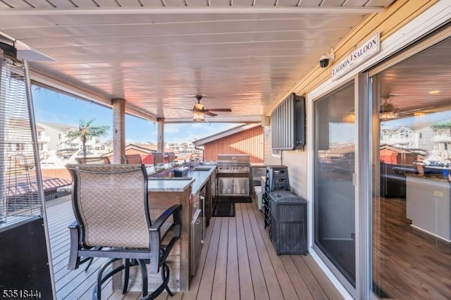 wooden terrace with a ceiling fan, a sink, and grilling area