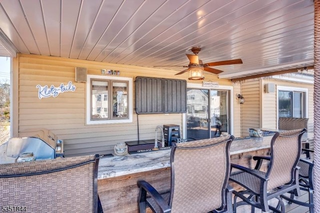 view of patio with outdoor dining area and a ceiling fan