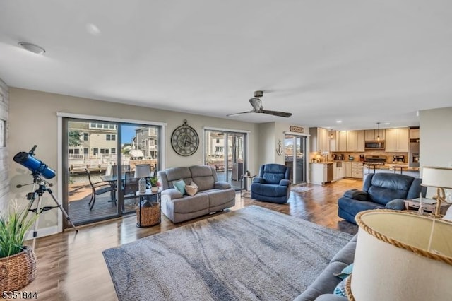 living room with recessed lighting, ceiling fan, baseboards, and light wood-type flooring