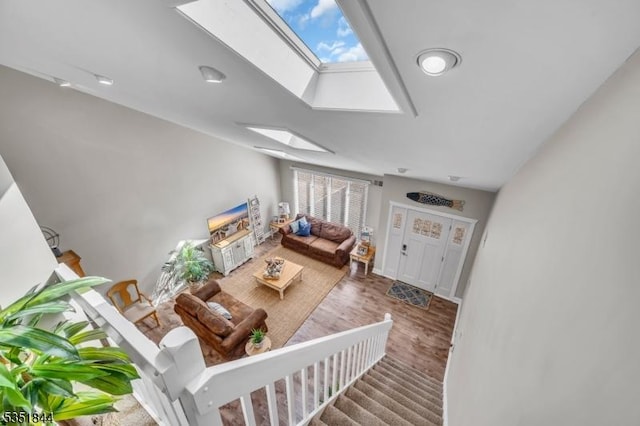 living room featuring a skylight, a healthy amount of sunlight, and wood finished floors