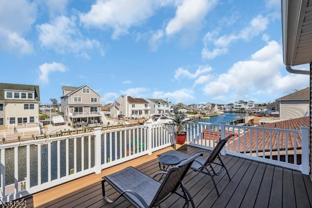 wooden terrace with a water view and a residential view