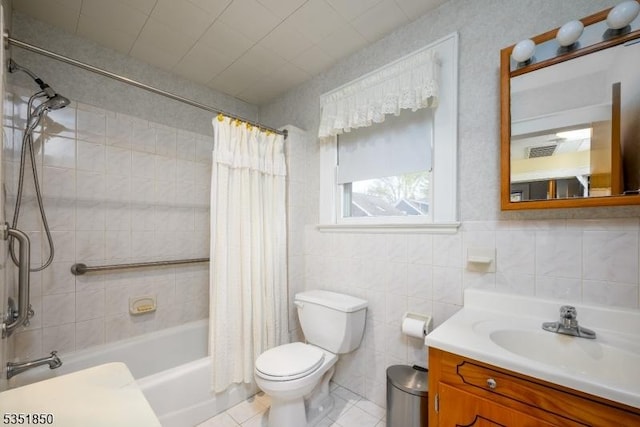 bathroom with toilet, shower / bath combination with curtain, vanity, tile patterned flooring, and tile walls