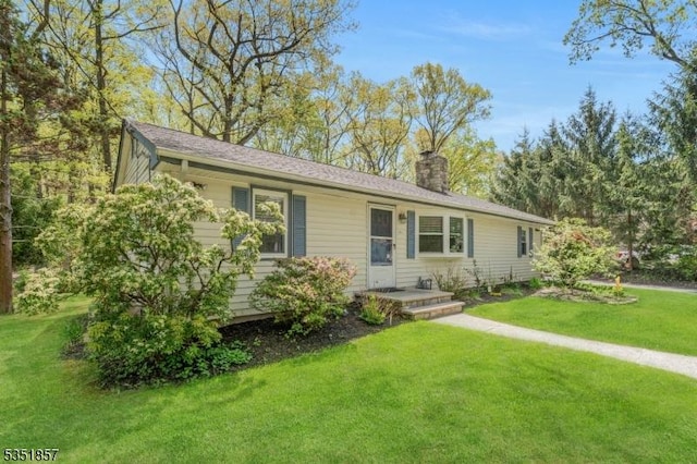 single story home featuring a chimney and a front yard