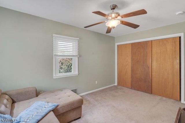 living area with baseboards, carpet, a ceiling fan, and visible vents