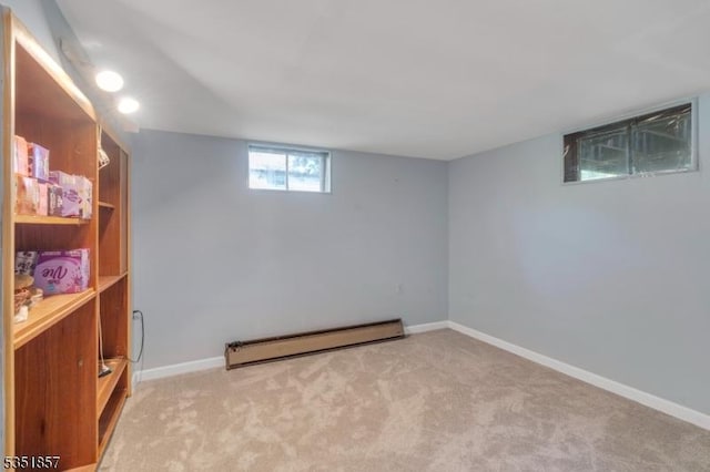 below grade area with carpet flooring, baseboards, and baseboard heating
