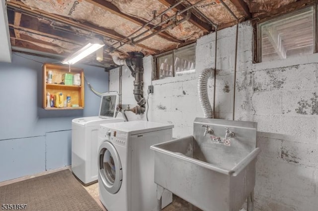 washroom with a sink, laundry area, and washer and dryer