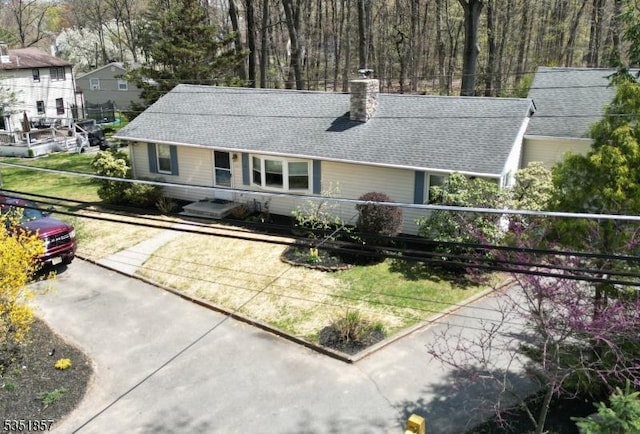 view of front of home featuring a shingled roof and a chimney