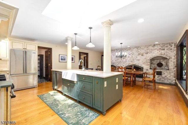70 Friar Ln, Watchung Boro, NJ 07069 - kitchen with green cabinets, appliances with stainless steel finishes, a sink, light wood-style flooring, and decorative columns